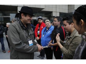 David Jackson, right, takes in the smoke from the burning sage held by First Nation Chief Duke Peltier during a cleansing ceremony outside the First Championship robotics competition, Friday, April 26, 2019, in Detroit. The First Nations STEM team that qualified for its first FIRST Championship is Ontario-based and is the only team made up of all indigenous students.