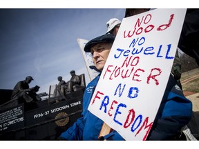 Genesee County Clerk-Register John Gleason protests alongside a dedicated handful United Auto Workers retirees during a protest against former UAW 1-C Director Norwood Jewell, Tuesday, April 2, 2019 at Sitdowners Memorial Park in Flint, Mich. Jewell is expected to enter a plea agreement Tuesday, on charges related to misuse of union workers' training funds. The retired UAW workers who protested are asking for all mentions of Jewell's name to be removed from the park.