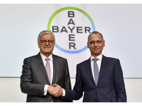 CEO Werner Baumann, right, and Chairman of the Supervisory Board Werner Wenning, left, shake hands during the annual general meeting of the Bayer stock company in Bonn, Germany, Friday, April 26, 2019. Following the record acquisition of U.S. biotech and seed company Monsanto, Bayer's agricultural business has become a risk for the German chemical company. Bayer is facing enormous cost if the U.S. court will find Monsanto's glyphosate to be causing cancer. Since the take-over of Monsanto in June 2018, Bayer lost around half of its value in market capitalization.