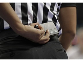 In this photo taken March 8, 2019, a referee prepares to start a play using a Precision Time device during the first half of an Atlantic Coast Conference women's tournament basketball game in Greensboro, N.C. The Precision Time system created more than two decades ago by former referee Mike Costabile currently is used at nearly every level of the sport, including the NBA and college basketball's NCAA Tournament. Costabile estimates the ability to stop the clock automatically on a referee's whistle can save roughly 90 seconds formerly lost to reaction time when timekeepers manually stopped the clock.
