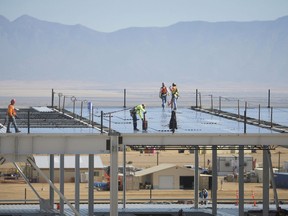FILE - In this Nov. 14, 2017, file photo, construction workers build one of the Facebook data center buildings in Los Lunas, N.M. A powerful regulatory authority in New Mexico decided Tuesday, April 16, 2019, it is requiring the state's largest utility to bill Facebook $39 million for the construction of a new transmission line, a move that the social media giant says could affect its long-term operations in the state.