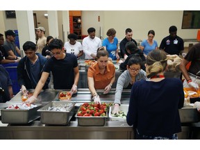 In this March 26, 2019, photo, volunteers put together food trays at Three Square, a food bank in Las Vegas. The reduction of food waste has taken hold in a city known for excess: Las Vegas. Sin City's world-famous casinos in recent years have developed and expanded innovative practices to cut back on the leftover and uneaten food they send to the landfill by thousands of tons a year. In 2016, MGM began donating fully cooked but never-served meals from conventions and other large events to Three Square, southern Nevada's only food bank.