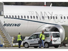 FILE - In this March 14, 2019, file photo, workers walk next to a Boeing 737 MAX 8 airplane parked at Boeing Field, in Seattle. A published report says pilots of an Ethiopian airliner that crashed followed Boeing's emergency steps for dealing with a sudden nose-down turn but couldn't regain control.