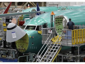 FILE - In this March 27, 2019, file photo, a worker enters a Boeing 737 MAX 8 airplane during a brief media tour of Boeing's 737 assembly facility in Renton, Wash. A published report says pilots of an Ethiopian airliner that crashed followed Boeing's emergency steps for dealing with a sudden nose-down turn but couldn't regain control.