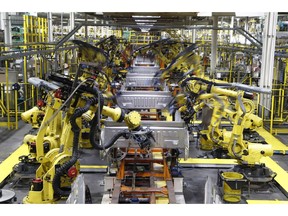 FILE- In this Sept. 27, 2018, file photo robots weld the bed of a 2018 Ford F-150 truck on the assembly line at the Ford Rouge assembly plant in Dearborn, Mich. On Monday, April 1, the Institute for Supply Management, a trade group of purchasing managers, issues its index of manufacturing activity for March.