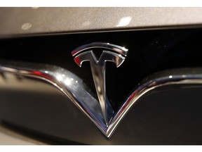 FILE- This Oct. 3, 2018, file photo shows a Tesla emblem at the Auto show in Paris. Tesla CEO Elon Musk appears poised to transform the company's electric cars into driverless vehicles in a risky bid to realize a bold vision that he has been floating for years. The technology required to make that quantum leap is scheduled to be shown off to Tesla investors Monday, April 22, 2019, at the company's Palo Alto, Calif., headquarters.