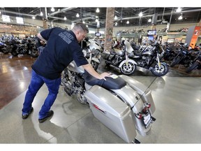 FILE - In this June 26, 2018, file photo, Jason Davis, an employee at the Dillon Brothers Harley Davidson dealership, moves a Street Glide Harley Davidson motorcycle which was sold, at in Omaha, Neb. Harley-Davidson Inc. on Tuesday, April 23, 2019, reported first-quarter earnings of $127.9 million.