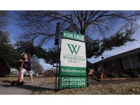 FILE - In this Feb. 20, 2019, file photo a girl pushes herself on a scooter by a home for sale in the Dallas suburb of Richardson, Texas. On Tuesday, April 30, the Standard & Poor's/Case-Shiller 20-city home price index for February is released.