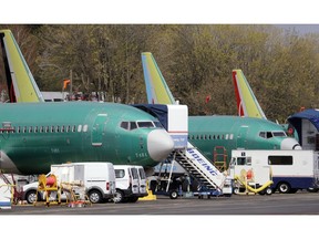 FILE - In this Monday, April 8, 2019, file photo, Boeing 737 Max 8 jets, built for American Airlines, left, and Air Canada are parked at the airport adjacent to a Boeing Co. production facility in Renton, Wash. Orders and deliveries of Boeing's 737 Max plunged in the first quarter as the plane was grounded around the world following a second deadly crash. Boeing disclosed Tuesday, April 9, that it received no new orders for the Max in March.