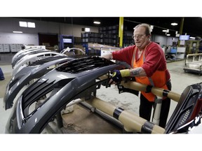 FILE - This Nov. 28, 2018 file photo shows Clifford Goff, a bezel assembler, transferring a front end of a General Motors Chevrolet Cruze during assembly at Jamestown Industries, in Youngstown, Ohio. On Tuesday, April 16, 2019, the Federal Reserve reports on U.S. industrial production for March.