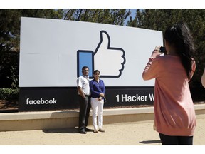 FILE - In this Aug. 31, 2016, file photo, visitors take photos in front of the Facebook logo outside of the company's headquarters in Menlo Park, Calif. Facebook reports earnings Wednesday, April 24, 2019.