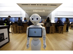FILE - In this March 21, 2019, file photo a robot called "Pepper" is positioned near an entrance to a Microsoft Store location, in Boston. Microsoft Corp. reports earnings Wednesday, April 24.