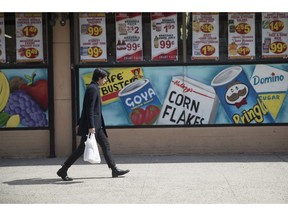 FILE- In this March 27, 2019, file photo a man leaves a supermarket in the East Village neighborhood of Manhattan carrying his groceries in a plastic bag. On Wednesday, April 10 the Labor Department reports on U.S. consumer prices for March.