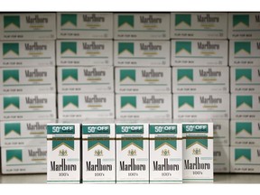 FILE- This June 14, 2018, photo shows Marlboro packs and cartons cigarettes, made by the Altria Group, on sale at JR outlet in Burlington, N.C. Shares of Altria Group, the nation's largest tobacco company, fell Thursday, April 25, 2019, after the company's earnings missed expectations on lower cigarette revenue and big expenses aimed at diversifying its business.