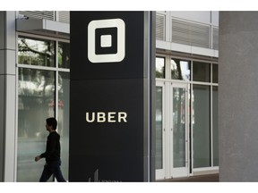 FILE- In this June 21, 2017, file photo a man walks into the building that houses the headquarters of Uber in San Francisco. Documents released Thursday, April 11, 2019, offered the most detailed view of the world's largest ride-hailing service since its inception a decade ago.