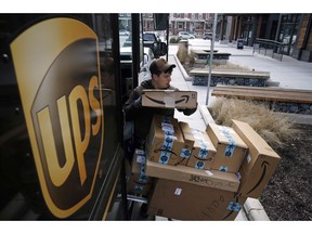 FILE- In this Dec. 19, 2018, file photo a UPS driver prepares to deliver packages. United Parcel Service Inc.  reports earns on Thursday, April 25, 2019.