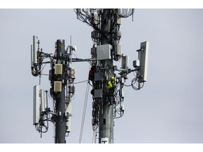 FILE- In this April 17, 2019, file photo workers install equipment on a communications tower in Philadelphia. On Friday, April 26, 2019, the Commerce Department issues the first estimate of how the U.S. economy performed in the January-March quarter.