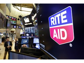 FILE- In this Aug. 9, 2018, file photo the logo for Rite Aid is displayed above a trading post on the floor of the New York Stock Exchange. Rite Aid will chop its share count by about 95% to make the remaining shares valuable enough to remain on the New York Stock Exchange. The struggling drugstore chain's board has approved a 1-for-20 ratio for a reverse stock split that shareholders backed in a vote last month. That will cut the company's share count from nearly 1.1 billion to about 54 million.