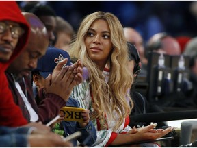 FILE - In this Feb. 19, 2017. file photo, Beyonce sits at court side during the second half of the NBA All-Star basketball game in New Orleans.  The pop star said on Thursday, April 4, 2019, she is on board as a creative partner for Adidas, and she will develop new footwear and apparel for the brand. Beyonce is also planning to re-launch her activewear clothing line, Ivy Park, with Adidas.
