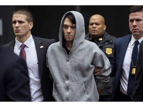 FILE - In this Dec. 17, 2015, file photo, Martin Shkreli, the former hedge fund manager under fire for buying a pharmaceutical company and ratcheting up the price of a life-saving drug, is escorted by law enforcement agents in New York, after being taken into custody following a securities probe. Pharmaceutical honcho Shkreli has been banished to solitary confinement amid allegations he was running his drug company from federal prison using a contraband smartphone, a person familiar with the matter told The Associated Press.