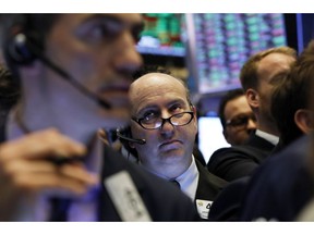 FILE - In this April 12, 2019, file photo trader Andrew Silverman, center, works on the floor of the New York Stock Exchange. The U.S. stock market opens at 9:30 a.m. EDT on Tuesday April 16.