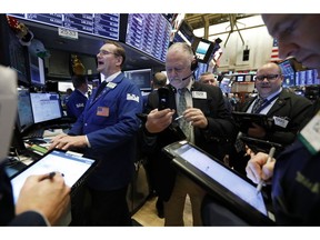 FILE- In this Feb. 12, 2019, file photo specialist Patrick King, left, works with traders at his post on the floor of the New York Stock Exchange. The U.S. stock market opens at 9:30 a.m. EDT on Wednesday, April 10.