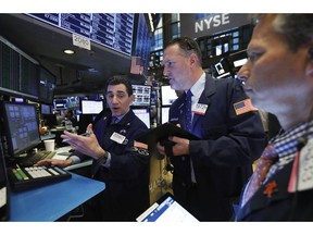 FILE - In this April 12, 2019, file photo specialist Peter Mazza, left, and trader Jonathan Corpina, center, work on the floor of the New York Stock Exchange. The U.S. stock market opens at 9:30 a.m. EDT on Wednesday, April 17.