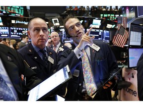 FILE - In this April 18, 2019, file photo traders Michael Urkonis, left, and Gregory Rowe, right, work on the floor of the New York Stock Exchange. The U.S. stock market opens at 9:30 a.m. EDT on Thursday, April 25.