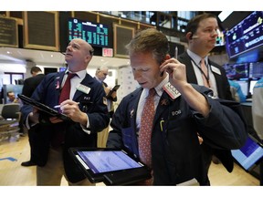 FILE- In this Feb. 12, 2019, file photo trader Robert Charmak, center, works on the floor of the New York Stock Exchange. The U.S. stock market opens at 9:30 a.m. EDT on Friday, April 12.
