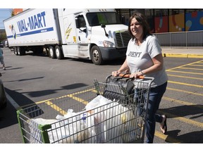 A customer pushes her cart into the parking lot after shopping at a Walmart Neighborhood Market, Wednesday, April 24, 2019, in Levittown, N.Y. The company has made the market into an artificial intelligence lab.