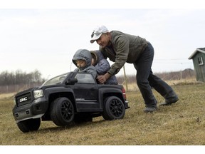 In this Thursday, March 28, 2019 photo, Eladio Beltran, right, pushes his children, Caleb, 4, left, and Jayem, 3, in their car at their home in Albion, N.Y. Beltran faces deportation because he was arrested for driving without a license. In New York and elsewhere, the idea of extending new privileges to those without legal immigration status has been resisted. But a renewed push across the country to allow them to get driver's licenses resonates strongly among those who make their living in the rural crop fields, dairy farms and fruit orchards where the need for everyday transportation can be the greatest.