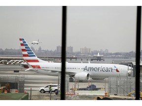 FILE - In a March 13, 2019 file photo, an American Airlines Boeing 737 MAX 8 sits at a boarding gate at LaGuardia Airport in New York. American Airlines said Sunday, April 7, 2019 it is extending by over a month its cancellations of about 90 daily flights as the troubled 737 Max plane remains grounded by regulators. The Boeing-made Max jets have been grounded in the U.S. and elsewhere since mid-March, following two deadly crashes in Ethiopia and Indonesia.