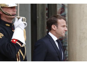 FILE - In this April 23, 2019 file photo, French President Emmanuel Macron waits for Japan's Prime Minister Shinzo Abe at the Elysee Palace in Paris. Macron is unveiling long-awaited plans to quell the yellow vest anti-government protests that have marred his presidency. He is planning to respond to yellow vest demonstrators' concerns over their loss of purchasing power with tax cuts for lower-income households and measures to boost pensions and help single parents