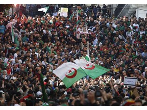 Demonstrators wave the Algerian flag as thousands gather for a rally in Algiers, Friday April 5, 2019, chanting, singing and cheering after their movement forced out longtime President Abdelaziz Bouteflika - and demanding that other top figures leave too. Crowds massed Friday in Algiers boulevards and headed toward the central post office, symbol of the movement that has upended this energy-rich North African country.