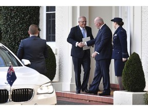 Australian Prime Minister Scott Morrison, second left, shakes hands with Governor General Peter Cosgrove as he leaves Government House in Canberra, Thursday, April 11, 2019, after a meeting to dissolve parliament and head for a Federal Election.