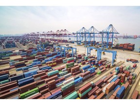 FILE - In this March 8, 2019, file photo, trucks move at a container port in Qingdao in eastern China's Shandong Province. China's economic growth held steady in the latest quarter amid a tariff war with Washington in a sign Beijing's efforts to reverse a slowdown might be gaining traction. (Chinatopix via AP, File)