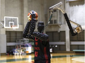 Toyota's basketball robot Cue 3 demonstrates Monday, April 1, 2019 at a gymnasium in Fuchu, Tokyo. The 207-centimeter (six-foot-10) -tall machine made five of eight three-pointer shots in a demonstration in a Tokyo suburb Monday, a ratio its engineers say is worse than usual. Toyota Motor Corp.'s robot, called Cue 3, computes as a three-dimensional image where the basket is, using sensors on its torso, and adjusts motors inside its arm and knees to give the shot the right angle and propulsion for a swish.