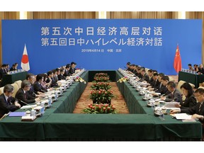 Japanese Foreign Minister Taro Kono, eight from left, and China's Foreign Minister Wang Yi, ninth from right, attend the Japan-China high level economic dialogue at Diaoyutai State Guesthouse in Beijing, China, Sunday, April 14, 2019.