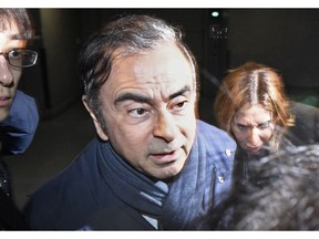 FILE - In this April 3, 2019, file photo, former Nissan Chairman Carlos Ghosn, center, leaves his lawyer's office in Tokyo. Nissan Chief Executive Hiroto Saikawa has apologized to shareholders for the unfolding scandal at the Japanese automaker and asked for their approval to oust from the board former Chairman Ghosn, who has been arrested on financial misconduct charges. Saikawa and other Nissan Motor Co. executives bowed deeply at a Tokyo hotel Monday, April 8, 2019, where the extraordinary shareholders' meeting was being held.