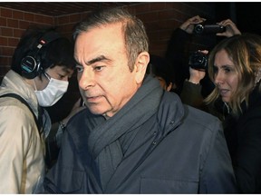 FILE - In this April 3, 2019, file photo, former Nissan Chairman Carlos Ghosn, center, returns to his residence in Tokyo.  Japanese court approves release for detained Nissan ex-chair Ghosn on 500 million yen, or $4.5 million, bail.(Kyodo News via AP)