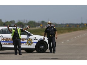 Harris County Constable Precinct 3 deputies direct traffic away from closed roads as firefighters battled a chemical fire at the KMCO plant Tuesday, April 2, 2019, in Crosby, Texas. A shelter-in-place was ordered for people living within one-mile radius of the plant.