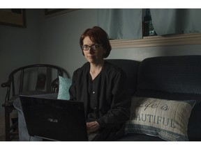 In this Friday, April 5, 2019, photo, Kelly Povroznik poses for a portrait inside the living room of her home in Weston, W.Va. Povroznik teaches an online college course that has been hampered by slow connections on her computer and phone. There is widespread agreement that expanding broadband internet in rural America is desperately needed.
