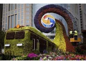 Workers on a platform install flowers on a decoration in a shape of a train for promoting the upcoming Belt and Road Forum in Beijing, Tuesday, April 23, 2019. The Belt and Road Forum which will open by Chinese President Xi Jinping this weekend in the capital city has draw leaders from around the globe. Xi, who has made the initiative a signature policy, agreed last month to seek fairer international trade rules and address the world's economic and security challenges, in what appeared to many as a rebuke to President Donald Trump's protectionist policies.