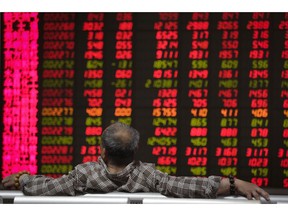 A man looks at an electronic board displaying stock prices at a brokerage house in Beijing, Wednesday, April 24, 2019. Shares were mostly lower in Asia on Wednesday despite the S&P 500's all-time record high close the day before.