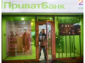FILE - In this file photo taken on Monday, Dec. 19, 2016, a client leaves PrivatBank as other clients take money from PrivatBank's cash machine in Kiev, Ukraine. A Ukrainian court has ruled that the 2016 nationalization of the major bank PrivatBank, owned by a powerful tycoon Ihor Kolomoyskyi, was illegal.