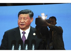 A cameraman films near a screen live broadcasting Chinese President Xi Jinping opening the Second Belt and Road Forum in Beijing Friday, April 26, 2019. The event celebrating the push for China-backed road, port and rail-building projects across the developing world, President Xi Jinping's signature foreign policy initiative, is one of Beijing's biggest of the year.