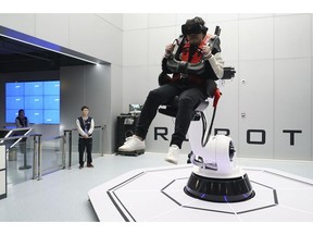 In this April 2, 2019, photo, a visitor rides a virtual roller coaster ride operated by a robotic arm in a VR theme park in Nanchang, China. One of the largest virtual reality theme parks in the world has opened its doors in southwestern China, sporting 42 rides and exhibits from VR bumper cars to VR shoot-em-ups. It's part of an effort by Beijing to get ordinary people excited about the technology - part of a long-term bet that VR will come into widespread use.