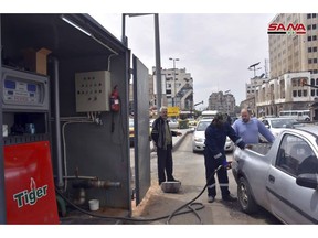 In this photo released on April 7, 2019, by the Syrian official news agency SANA, Shows a worker fills a pickup at a gas station, in Homs, Syria. Syrians living in government-controlled areas have survived eight years of war now face a new scourge in the form of widespread fuel shortages. (SANA via AP)