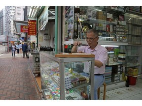 In this April 18, 2019, photo, Cheung Shun-king, 65-year-old maker of the popular table-top game mahjong tiles, engraves a character on a tile in his decades-old store in Kowloon's old neighborhood of Hong Kong. Hand-carved mahjong tiles is a dying art in Hong Kong.