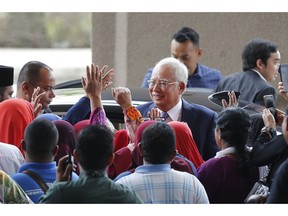 Former Malaysian Prime Minister Najib Razak, center, greets by supporters as he arrives Kuala Lumpur High Court in Kuala Lumpur, Malaysia, Wednesday, April 3, 2019. Najib Razak appeared in court Wednesday for the start of his corruption trial, exactly 10 years after he was first elected to office only to suffer a spectacular defeat last year on allegations he pilfered millions of dollars from a state investment fund.